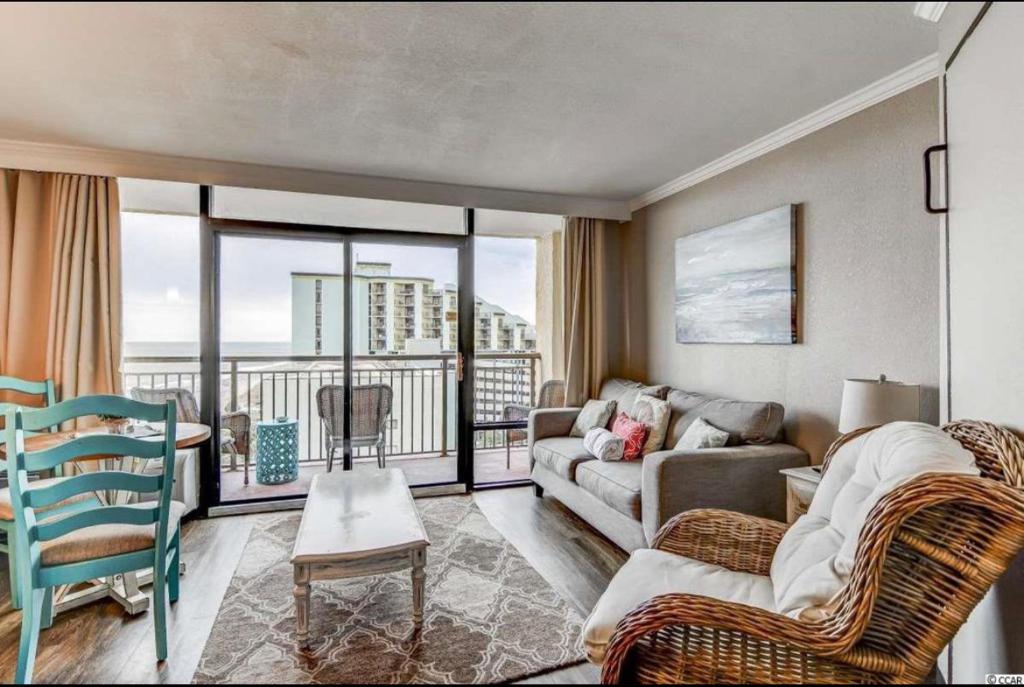 een woonkamer met een bank en stoelen en een balkon bij Oceanfront Condo in Myrtle Beach in Myrtle Beach