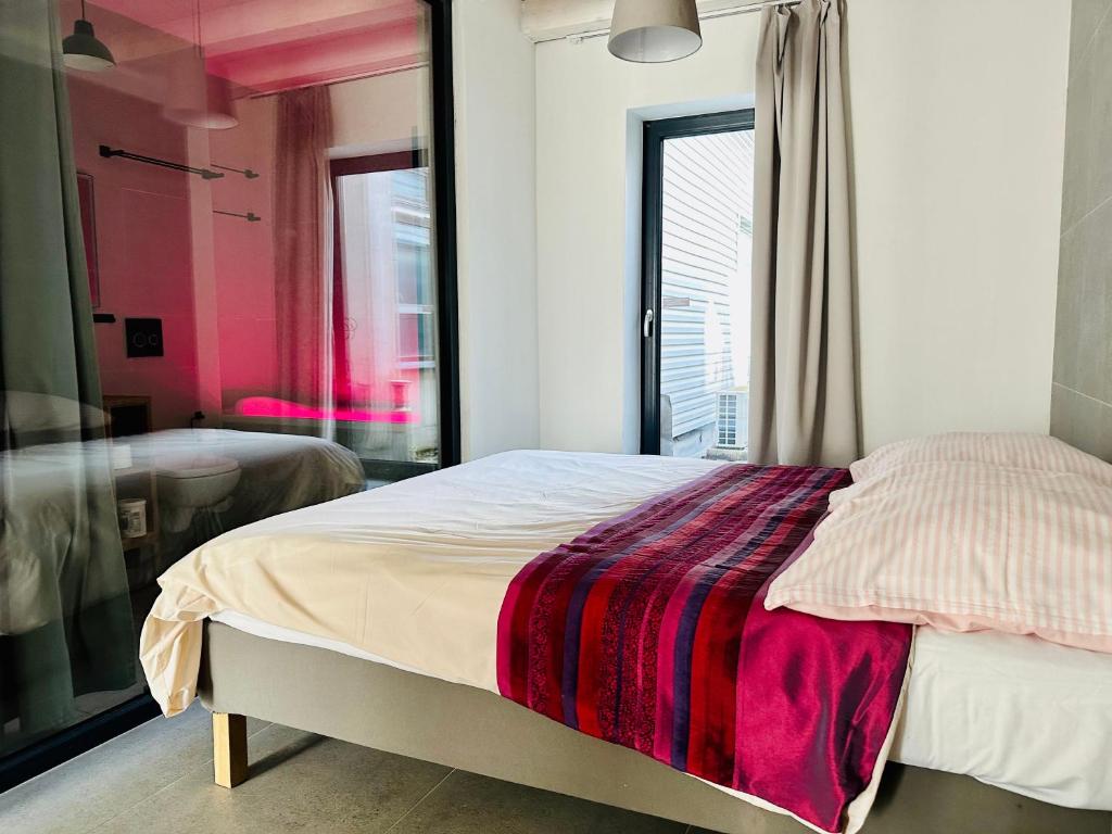 a bedroom with a bed with a red blanket on it at STONE Apartment in Žilina