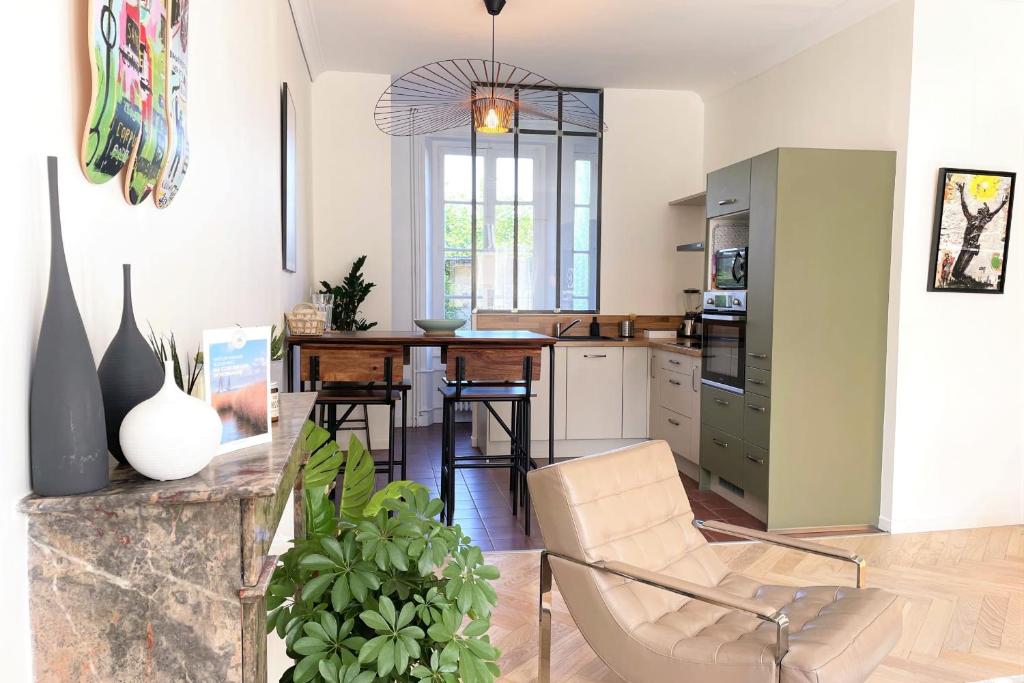 une cuisine avec une table et des chaises dans une pièce dans l'établissement Le Vertigo - Standing - Proche Mairie, à Caen