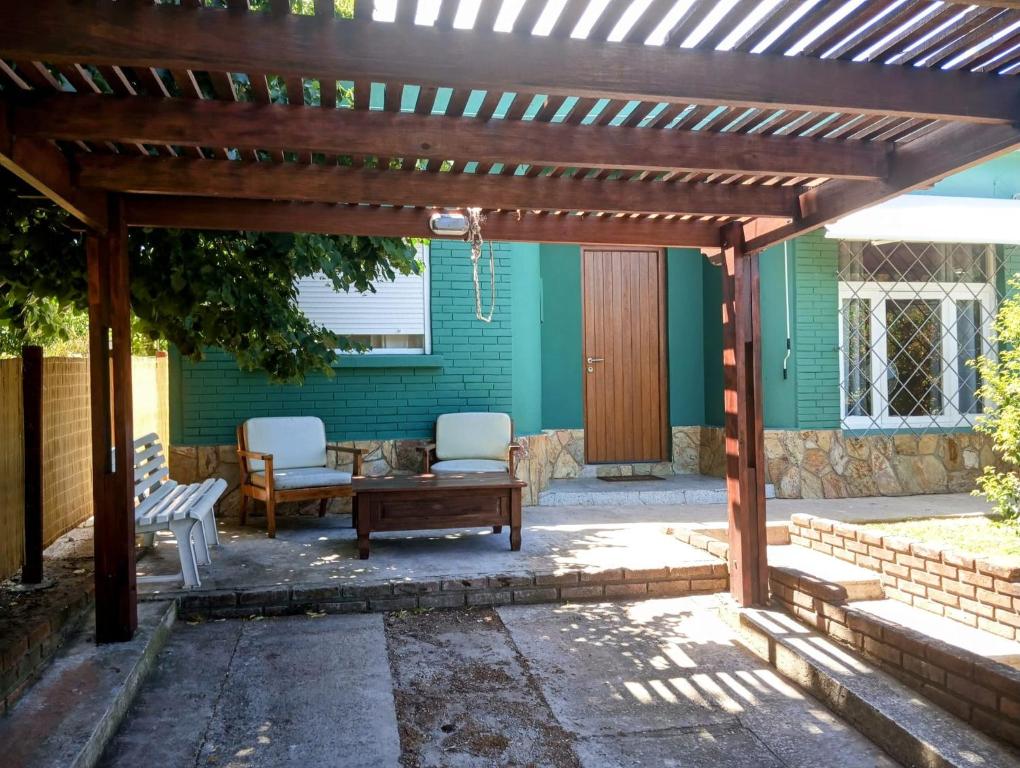 a wooden pergola with two chairs and a table at Colibrí in Piriápolis