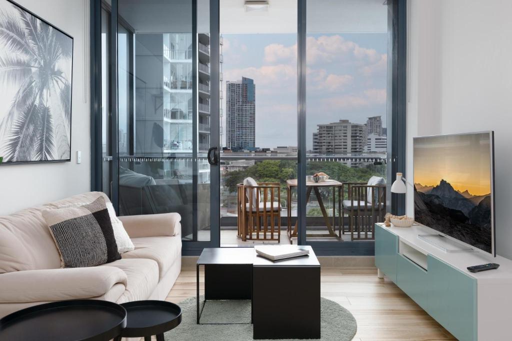 a living room with a couch and a tv at 703Mer in Gold Coast