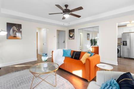 a living room with an orange couch and a ceiling fan at Affordable 1-BR by DMC Detroit in Detroit