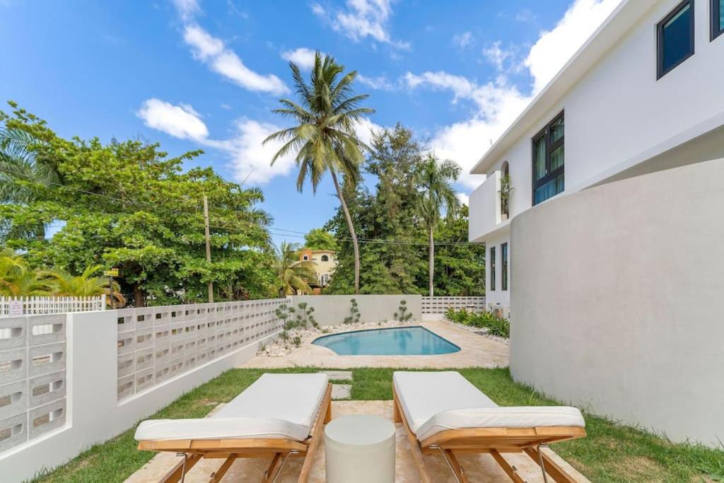 een achtertuin met een zwembad en een wit hek bij Casa Loba Luxe Apartment with pool and ocean views in Rincon