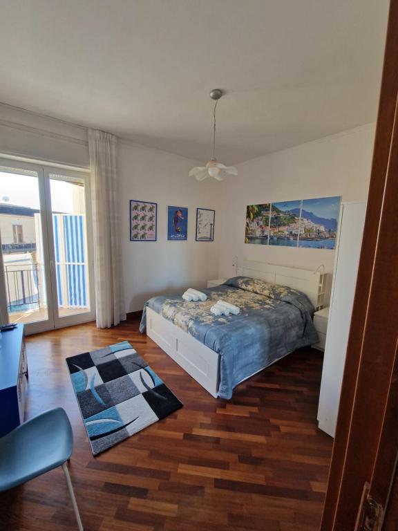 ein Schlafzimmer mit einem Bett in einem Zimmer mit Holzböden in der Unterkunft Il Nido di Nora - Apartment in Salerno