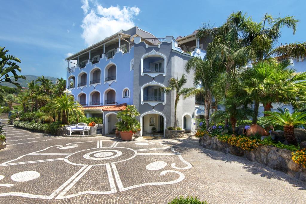 a large blue building with palm trees in front of it at Sorriso Thermae Resort & Spa in Ischia