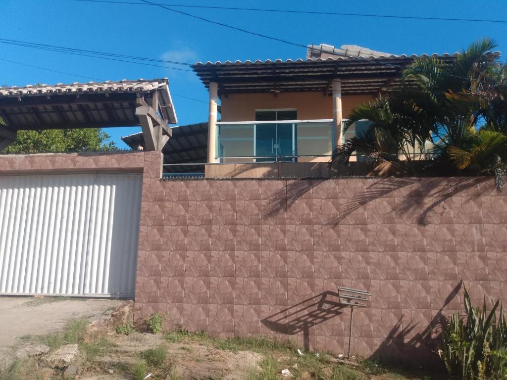 a house behind a brick wall with a gate at Casa de Dona Aida in Itaparica