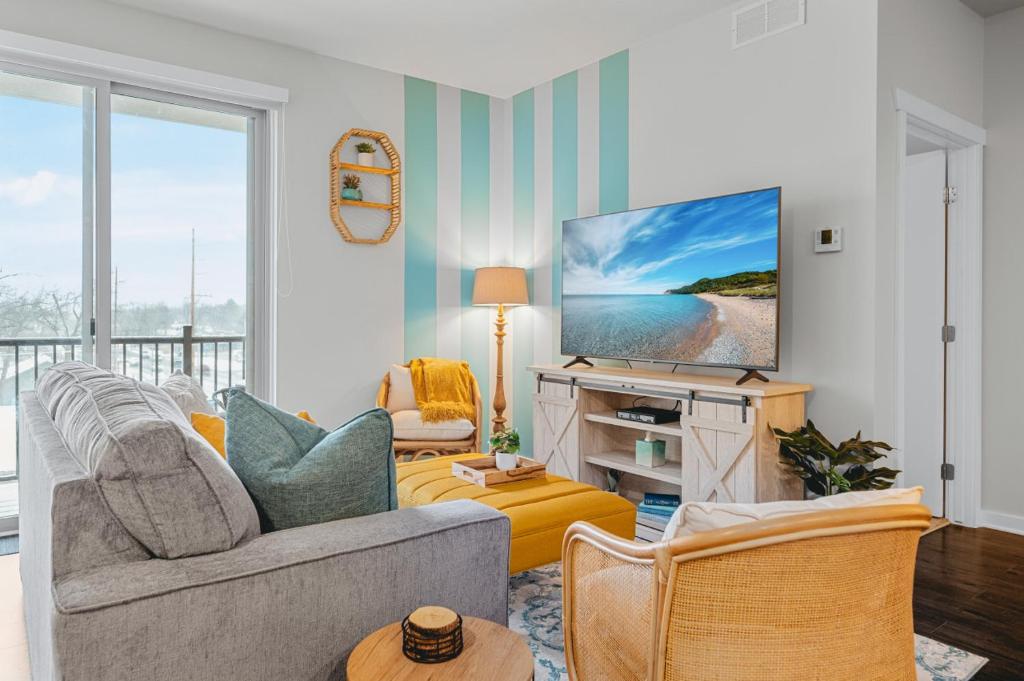 a living room with a couch and a tv at NEW Shoreline 401 2BR Condo Near Downtown and Bay in Traverse City