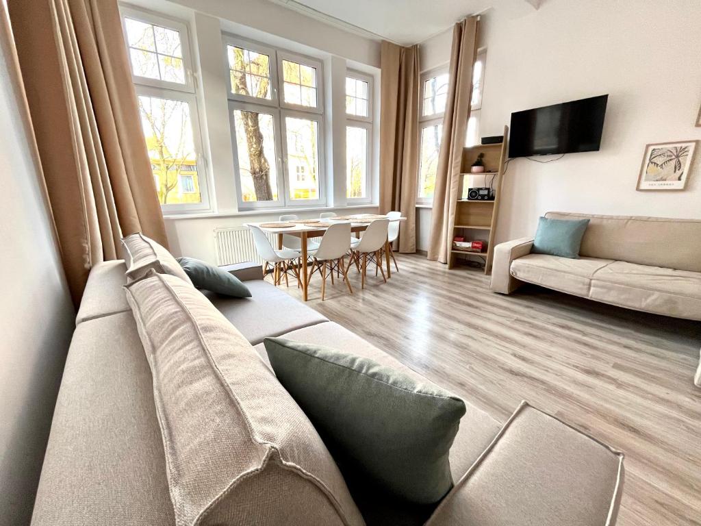 a living room with a couch and a table at Agapella Apartamenty - Apartament Goyki 300 m from the beach in Sopot