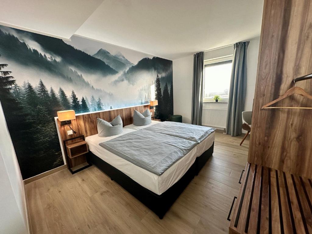 Schlafzimmer mit einem Bett mit Wandgemälde in der Unterkunft AUSZEIT DAS HOTEL Schweitenkirchen in Schweitenkirchen