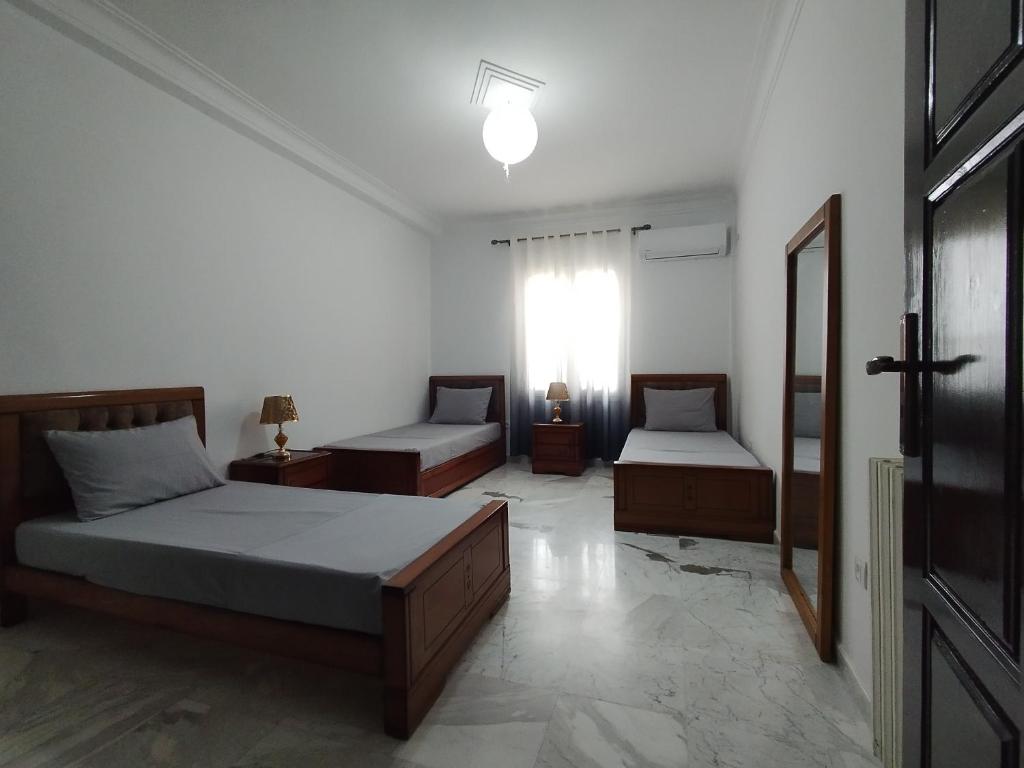 a bedroom with two beds and a window at Appartement à louer à Tlemcen in Tlemcen