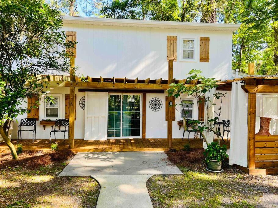 a white house with a porch and a patio at Beautiful farmhouse in Fernandina Beach in Fernandina Beach
