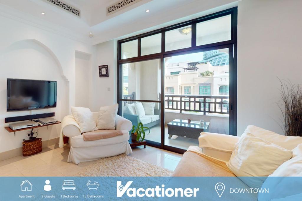 Al Tajer - Vacationer في دبي: غرفة معيشة مع كرسيين وتلفزيون