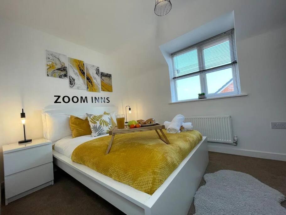 a white bedroom with a bed with a yellow blanket at Urban Oasis in Lively Selly Oak! in Birmingham