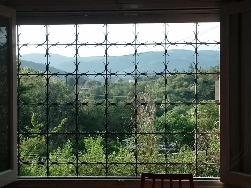 a window with a view of the forest at Chalet cuesta blanca in Villa Icho Cruz