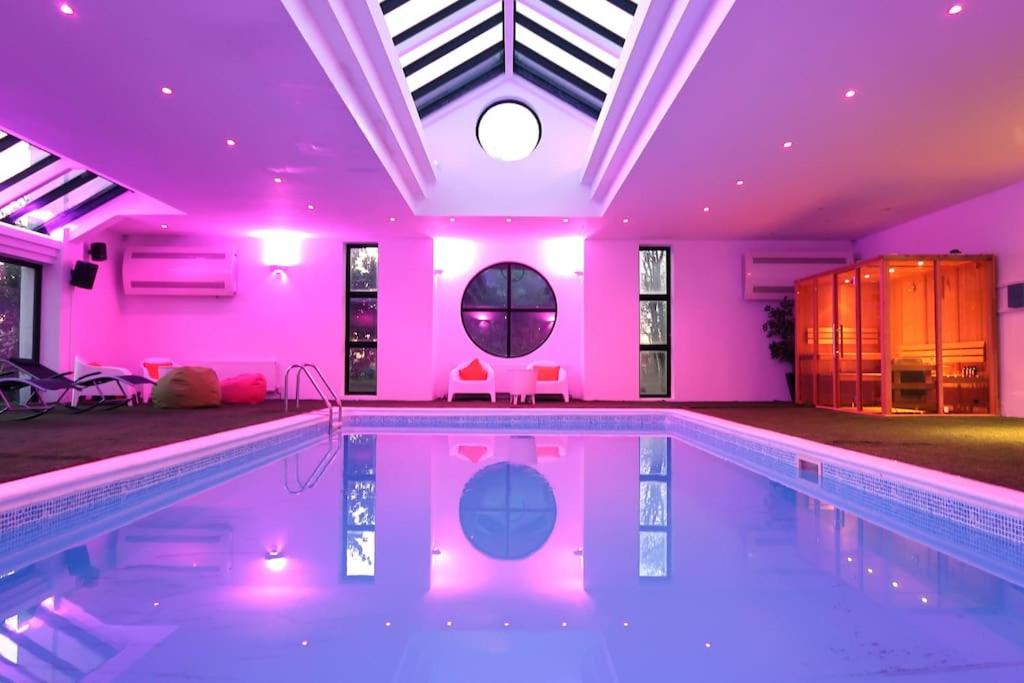 Ballyeaston的住宿－Entertainer's Estate，一座游泳池,里面设有粉红色的灯光