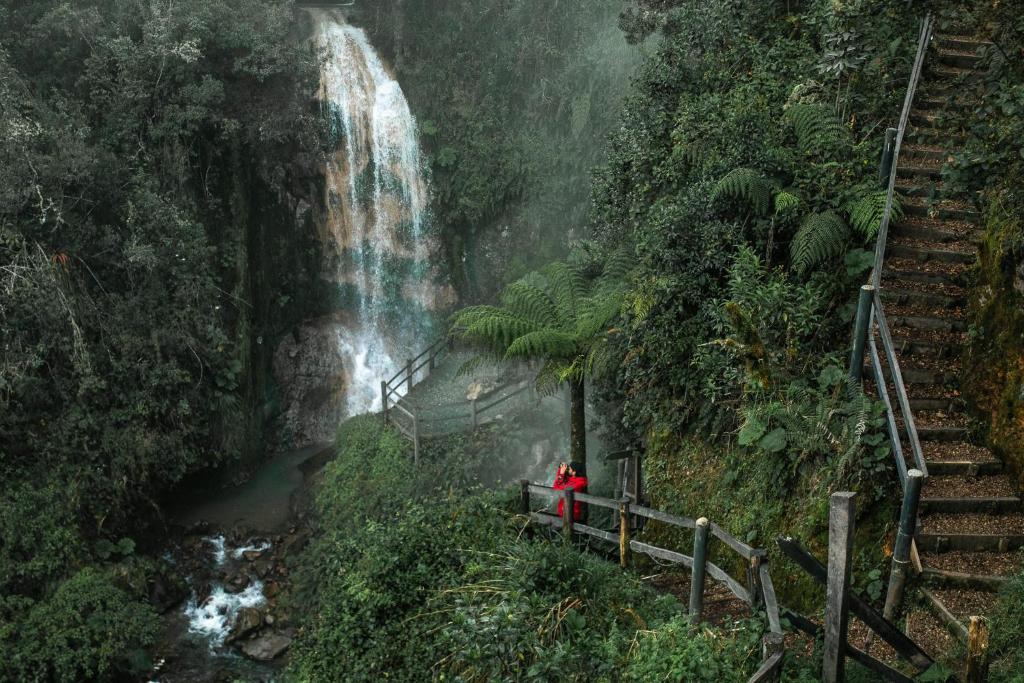 a person standing in front of a waterfall at Hotel Termales del Ruiz in Manizales