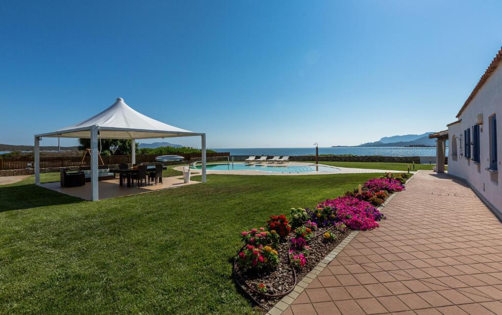 um jardim com um gazebo e algumas flores em Villa Cormorano em Olbia