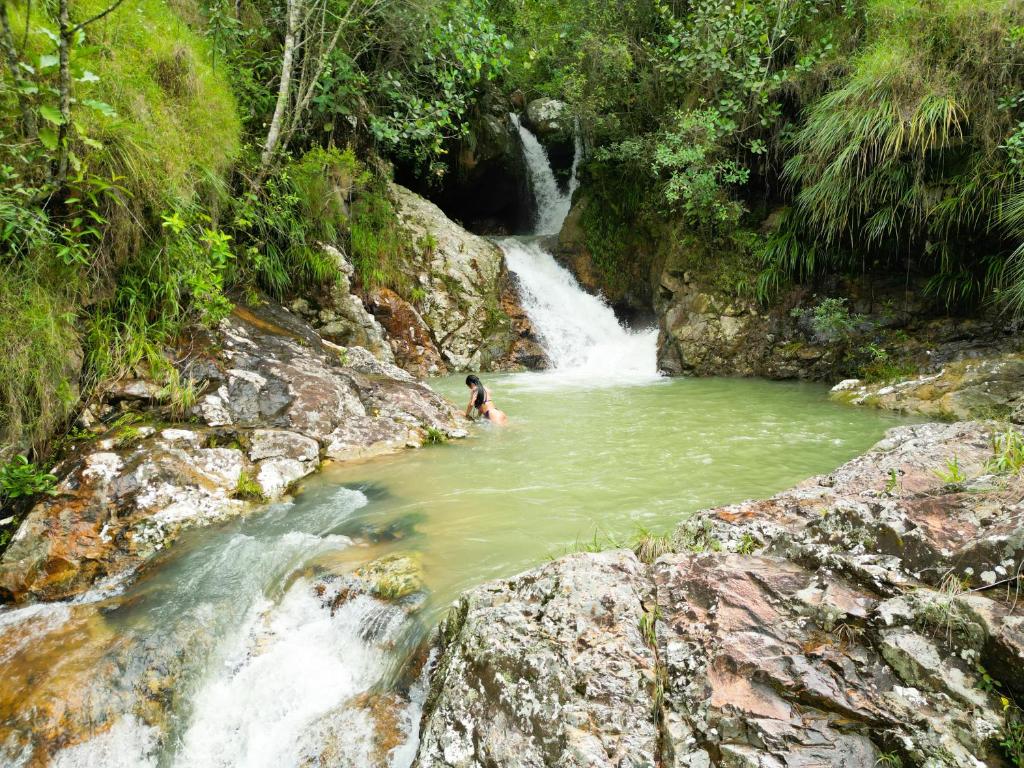a person swimming in a river in front of a waterfall at Finca Ecoturistica Xtremly 