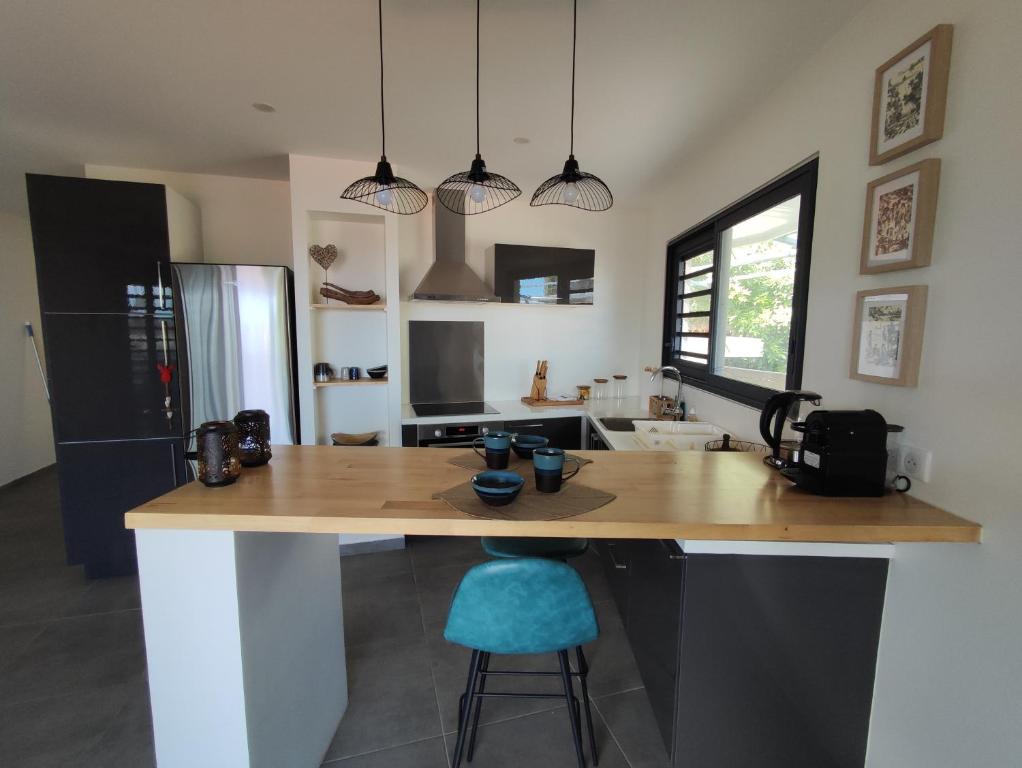 una cucina con bancone e sgabello blu di Le Fare Cosy Kiwi et le Fare Cosy Tiki a Faaa