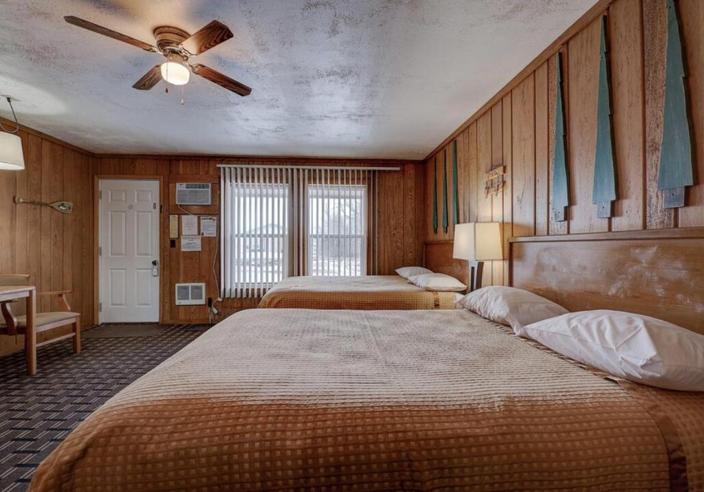 a bedroom with two beds and a ceiling fan at Okoboji Lodge in Spirit Lake