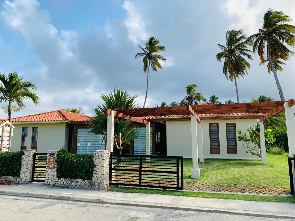 ein Haus mit Palmen im Hintergrund in der Unterkunft Casa MB 2 Los Cabos in Cabrera