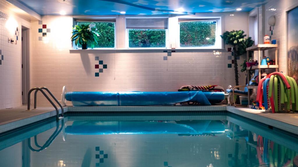 a swimming pool in a bathroom with a blue ceiling at Van Nest near YVR UBC Downtown in Vancouver