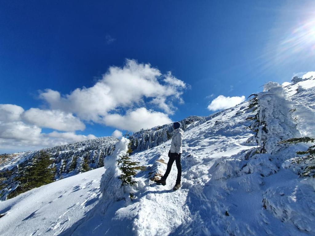 a person standing on top of a snow covered mountain at azila _ issagun 