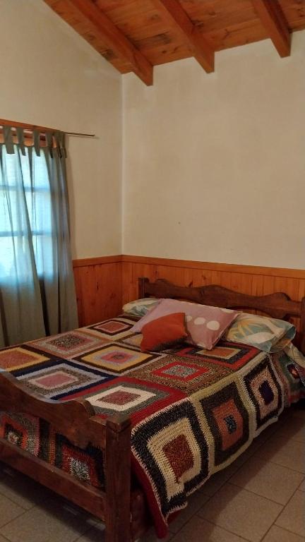 a bedroom with a bed with a quilt on it at Banim in El Hoyo