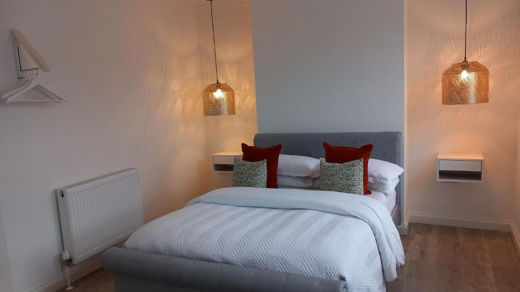 a bedroom with a bed with red pillows at Home Away from Home... in Kent