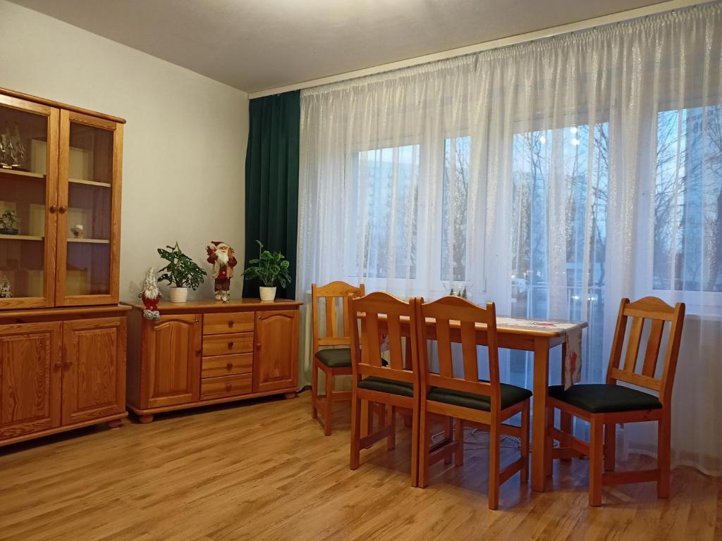 d'une salle à manger avec une table, des chaises et une fenêtre. dans l'établissement ,,Zielona przystań nad morzem" Gdańsk - Przymorze, à Gdańsk