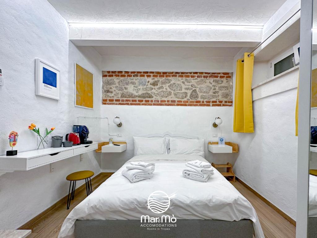 ein Schlafzimmer mit einem Bett in einem Zimmer in der Unterkunft MareMò Accomodations - Rooms in Tropea in Tropea