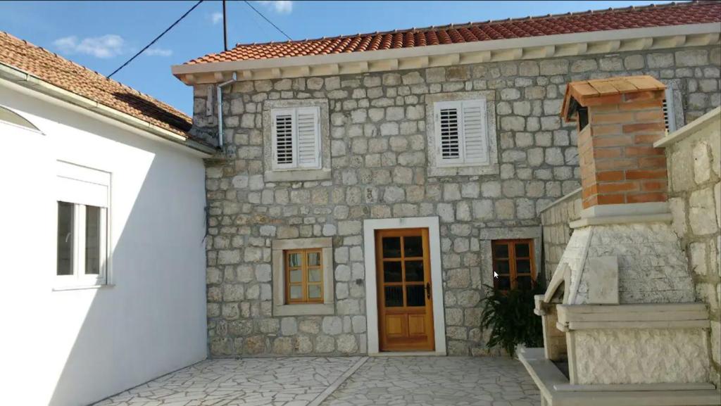 a stone house with a door and a building at Mediterranean stone house Ucović in Gruda