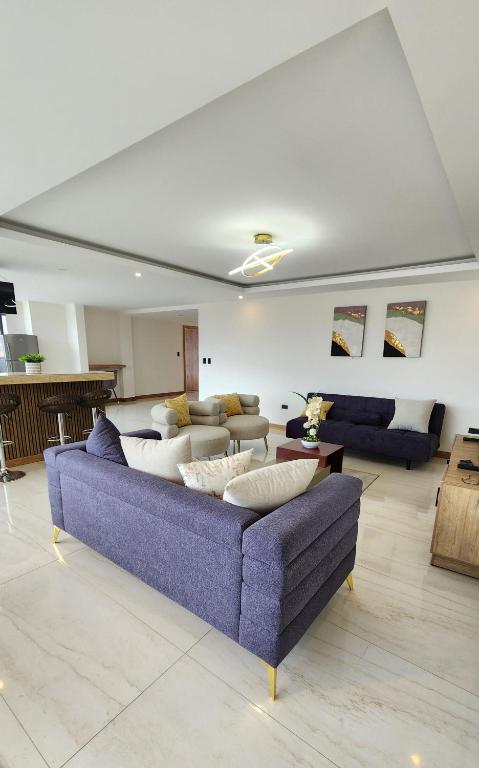a living room with a blue couch and tables at La Terraza suite de lujo 302 in Cuenca