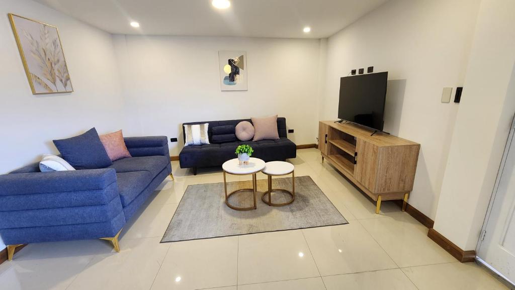 un salon avec un canapé bleu et une télévision dans l'établissement La Terraza departamentos 401, à Cuenca