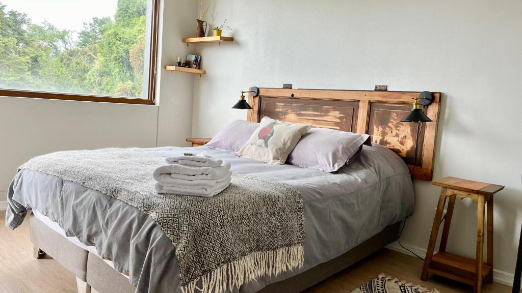 1 dormitorio con 1 cama con toallas en Vista al lago y excelente ubicación: hermoso depto, en Puerto Varas