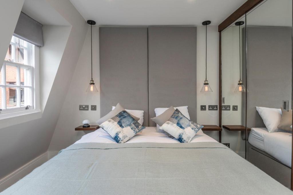 a bedroom with a large white bed with two pillows at Luxury Georgian House in Marylebone: Modern 1-Bed Retreat in London