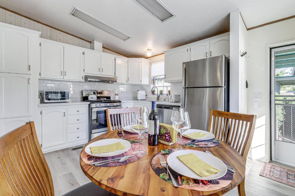 Il dispose d'une cuisine avec une table en bois, des chaises et un réfrigérateur. dans l'établissement Charming Petaluma Cottage with Grill Near Wineries, à Petaluma