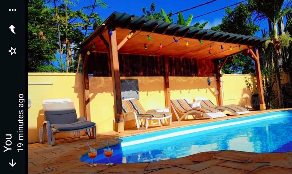 una piscina con sillas y un cenador en 3 bedrooms villa with shared pool furnished terrace and wifi at Pointe aux Piments, en Pointe aux Piments