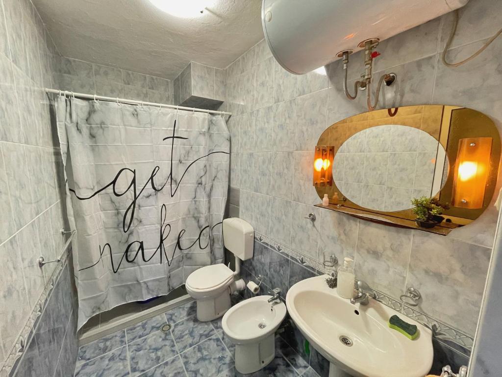 ein Badezimmer mit einem Waschbecken, einem WC und einem Spiegel in der Unterkunft Shkodra Apartment in Shkodra