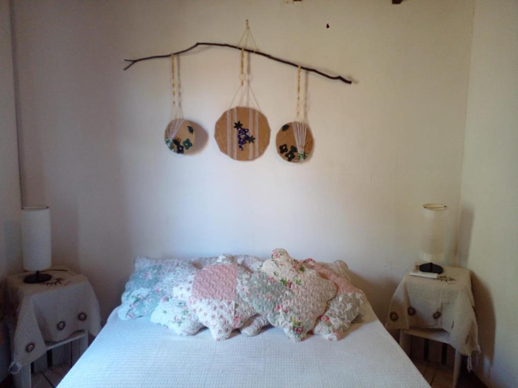 um quarto com uma cama com almofadas em La Gitana - Casa en La Paloma em La Paloma