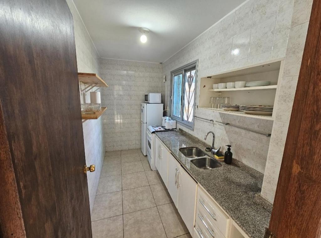 a kitchen with a sink and a refrigerator at Apart Hotel Punta Sol in Punta del Este