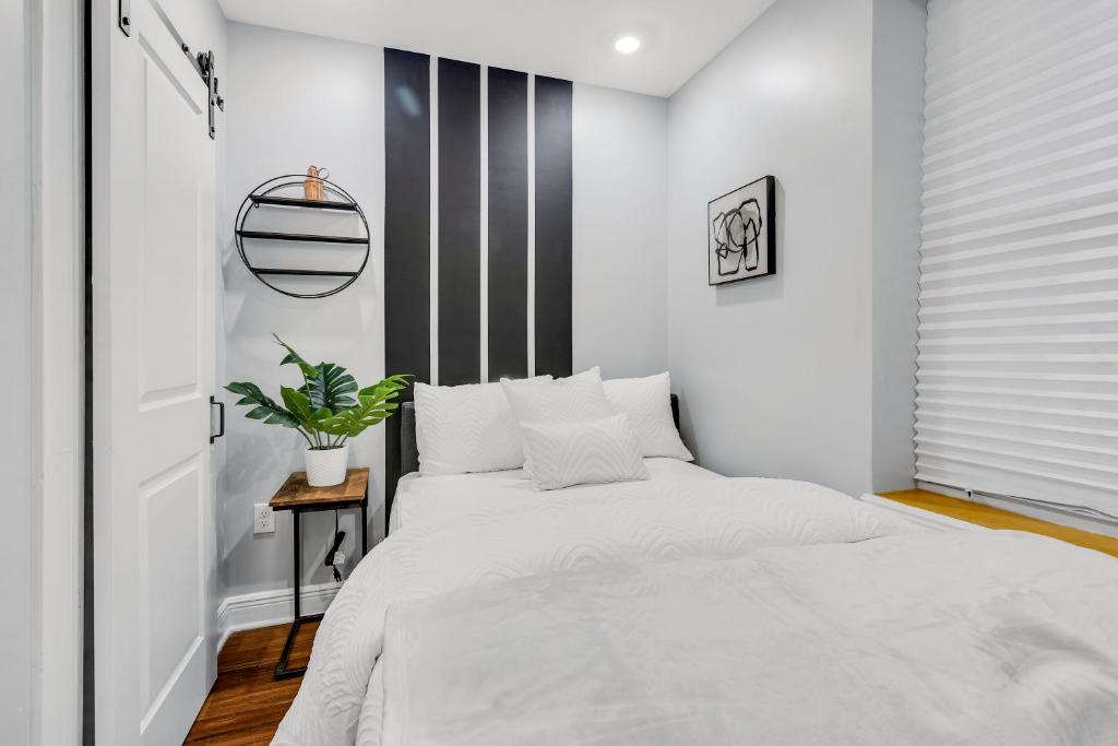 a bedroom with a white bed and a black and white wall at 1 BR Patio Paradise in Central City in Philadelphia