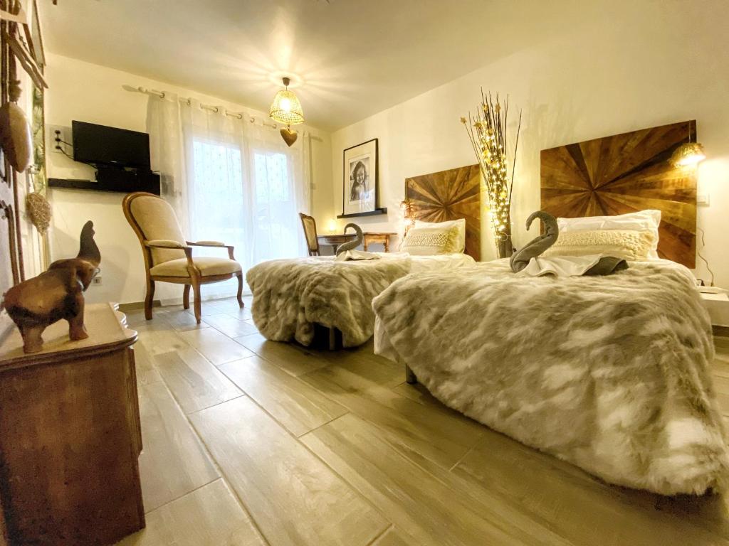 a bedroom with two beds and a table and chairs at DELUX L'EVASION in Saverne