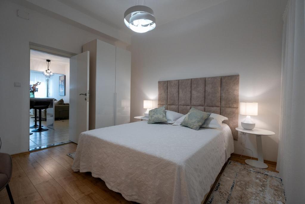 ein Schlafzimmer mit einem großen weißen Bett und zwei Lampen in der Unterkunft Adam 2 in Stobreč