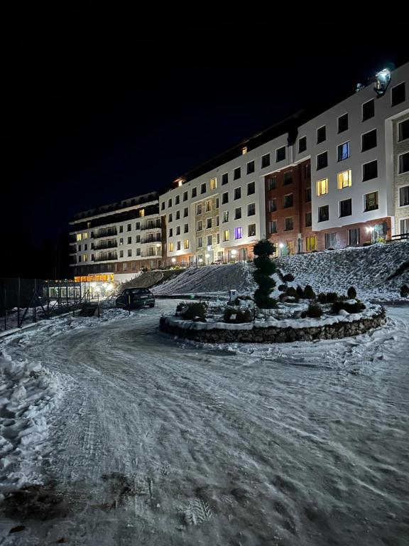 eine verschneite Straße vor einem Gebäude nachts in der Unterkunft Milmari Apartments - N Lux 108 - SPA OPENING DECEMBER 2025 in Kopaonik