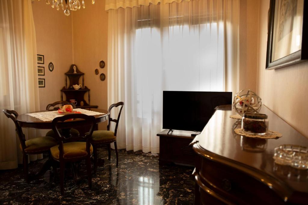 uma sala de estar com uma mesa de jantar e uma televisão em Casa Giuly em Parma
