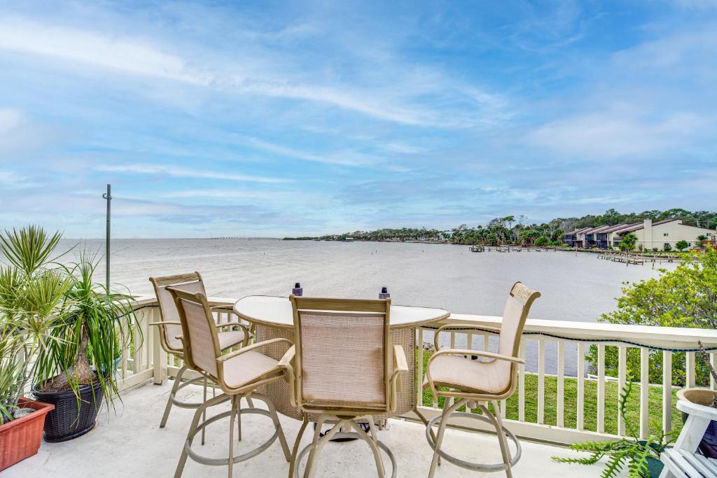 a table and chairs on a balcony with a view of the water at Riverfront Townhome in Titusville Community Pool in Titusville