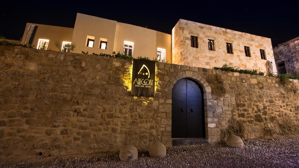 a building with a blue door on a stone wall at night at Allegory Boutique Hotel in Rhodes Town