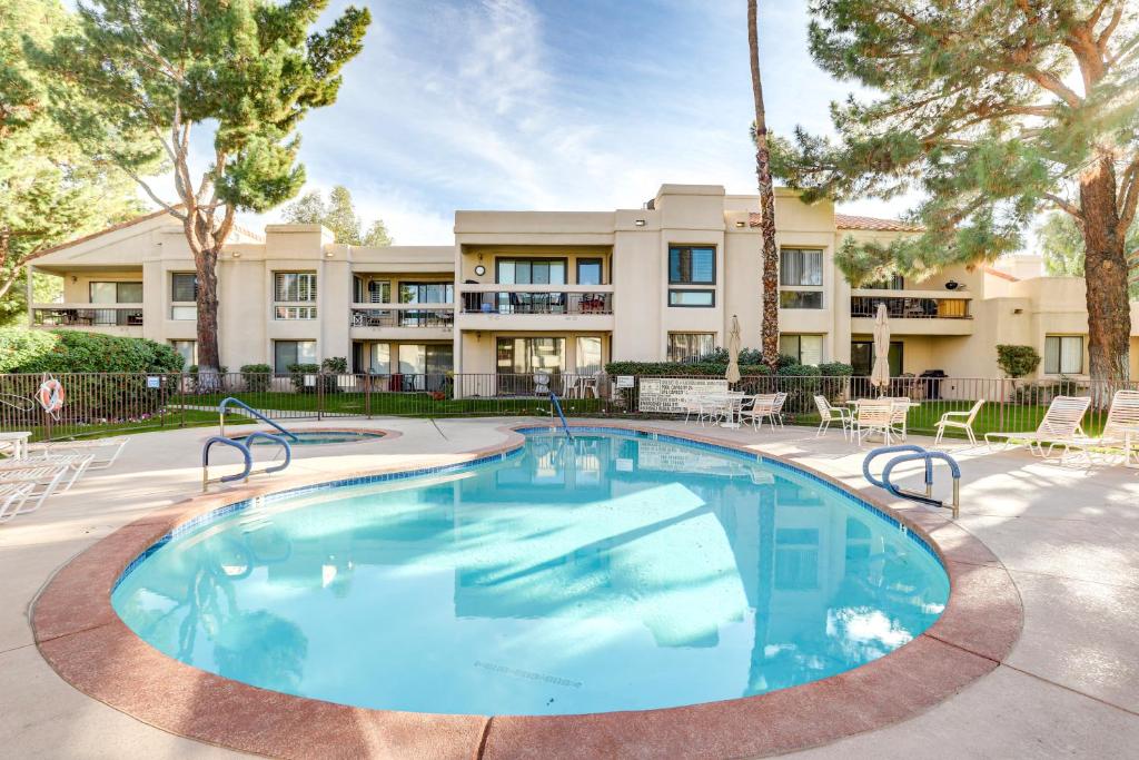 a large swimming pool in front of a building with trees at Cathedral City Condo with Community Pools and Hot Tubs in Cathedral City