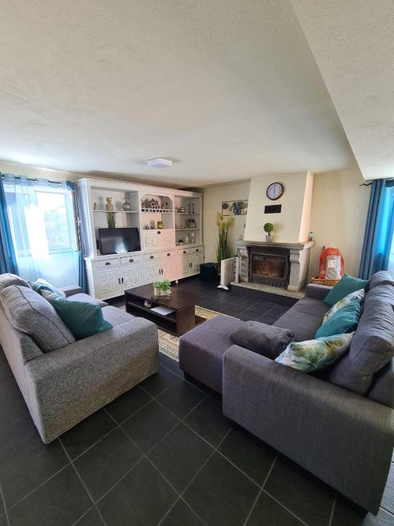 a living room with two couches and a fireplace at Casa dos Pinheiros - Serra da Estrela in Penhas da Saúde